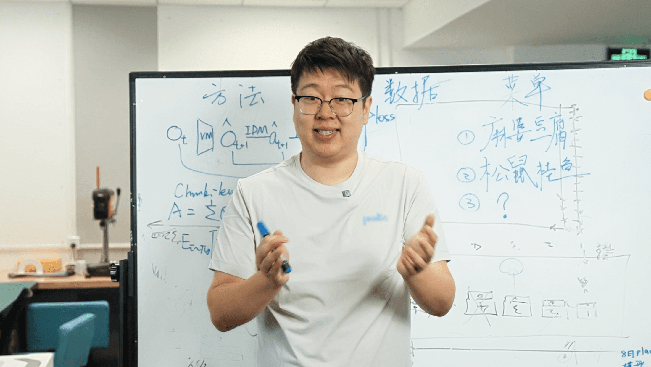 A Poke team member sharing robotics startup progress in front of a whiteboard